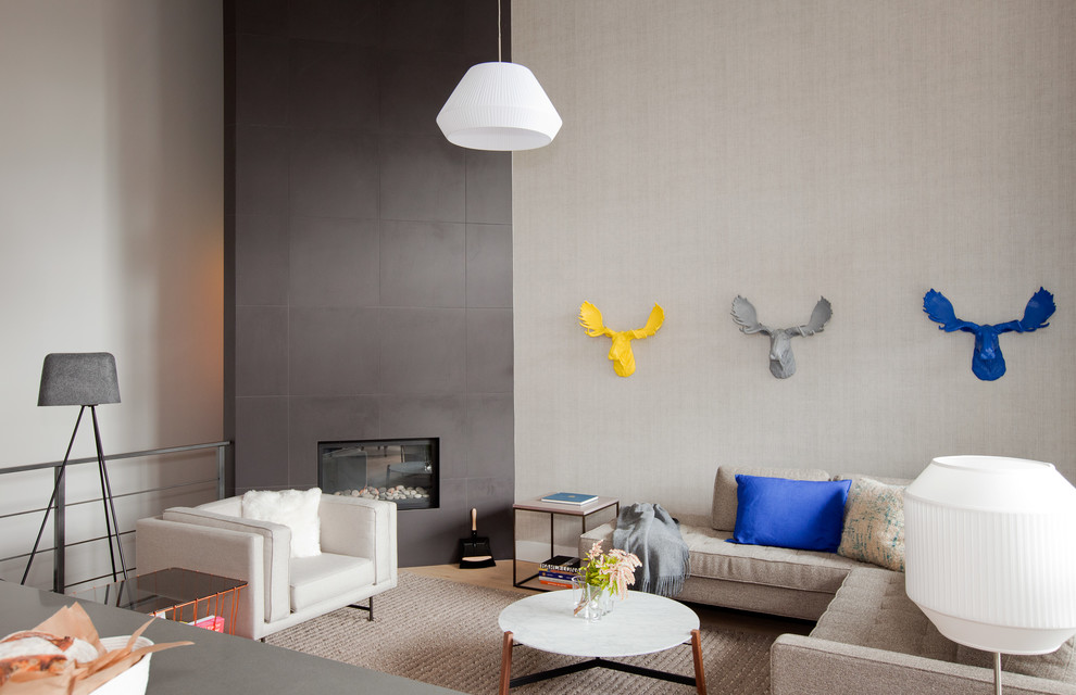 This is an example of a contemporary living room in Vancouver with grey walls and a corner fireplace.