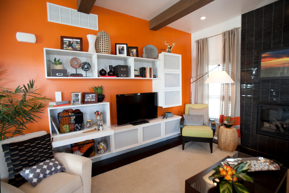 Свежая идея для дизайна: открытая гостиная комната среднего размера в стиле модернизм с оранжевыми стенами, темным паркетным полом, стандартным камином, фасадом камина из плитки и отдельно стоящим телевизором - отличное фото интерьера