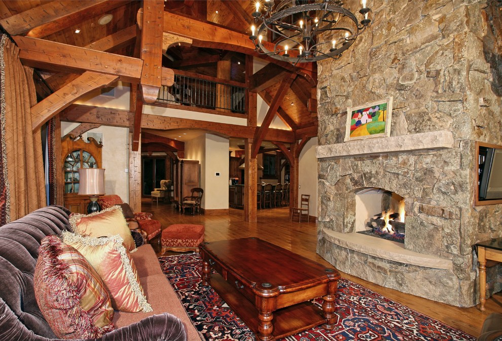 Example of a large classic formal and open concept medium tone wood floor living room design in Denver with beige walls, a standard fireplace, a stone fireplace and a wall-mounted tv