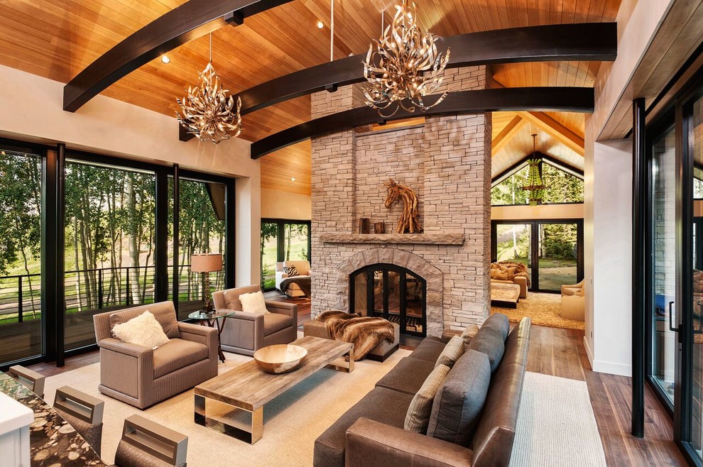 Inspiration for a modern open plan living room in Denver with grey walls, medium hardwood flooring, a two-sided fireplace, a stone fireplace surround and feature lighting.