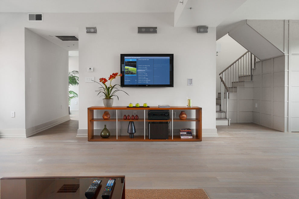 Inspiration för mellanstora moderna loftrum, med vita väggar, ljust trägolv och en väggmonterad TV