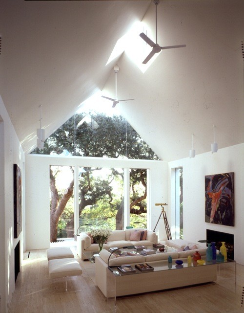 Exempel på ett stort modernt allrum med öppen planlösning, med ett finrum, vita väggar, ljust trägolv, en spiselkrans i sten och en dold TV