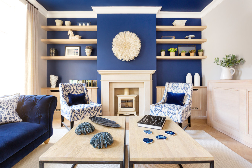 Réalisation d'un salon minimaliste avec un mur bleu, parquet clair, un poêle à bois et un sol beige.