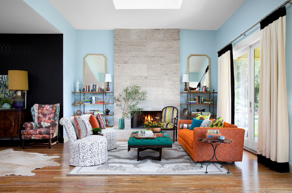 Example of a mid-sized eclectic formal and open concept medium tone wood floor and brown floor living room design in Austin with blue walls, a standard fireplace, a tile fireplace and no tv