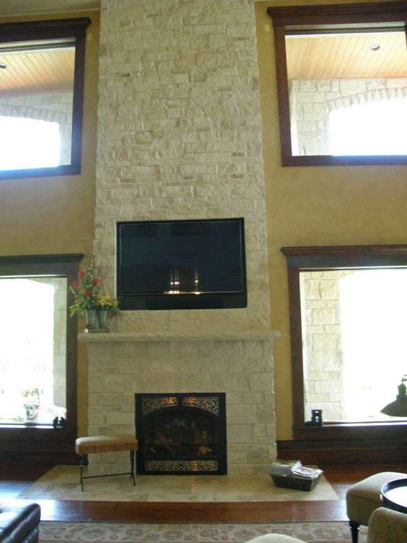 Example of a classic formal and open concept dark wood floor and brown floor living room design in Other with beige walls, a standard fireplace, a stone fireplace and a media wall