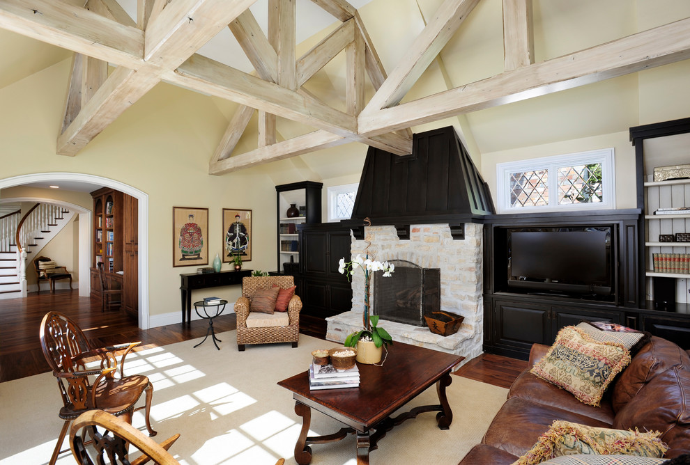 Example of a huge french country open concept medium tone wood floor living room design in San Francisco with a stone fireplace, yellow walls and a media wall