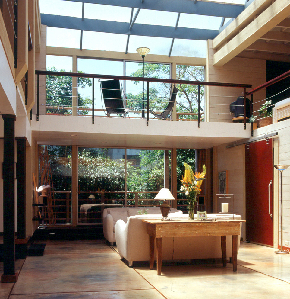 Ispirazione per un grande soggiorno stile marinaro stile loft con pareti beige e pavimento in cemento