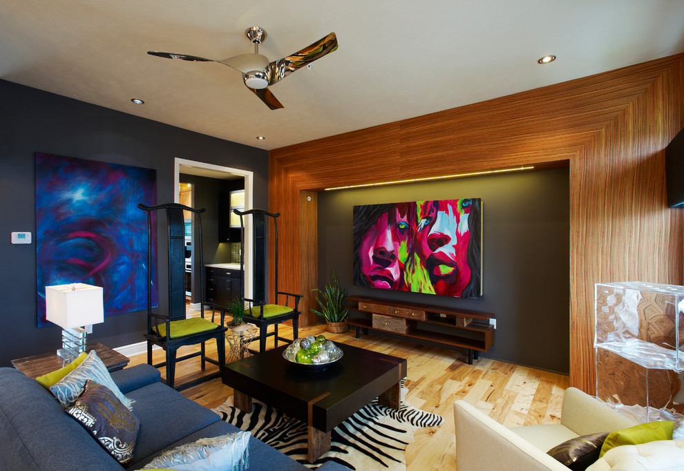 Example of a trendy enclosed medium tone wood floor living room design in Other with black walls
