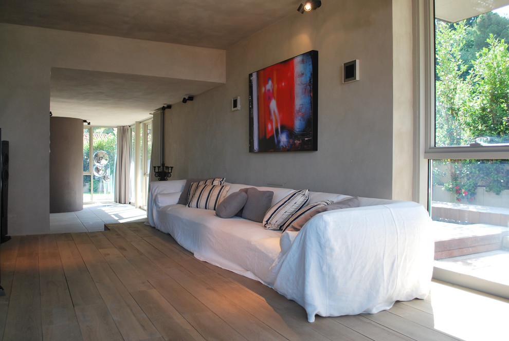 Immagine di un soggiorno minimal di medie dimensioni e aperto con sala della musica, pareti beige e parquet chiaro