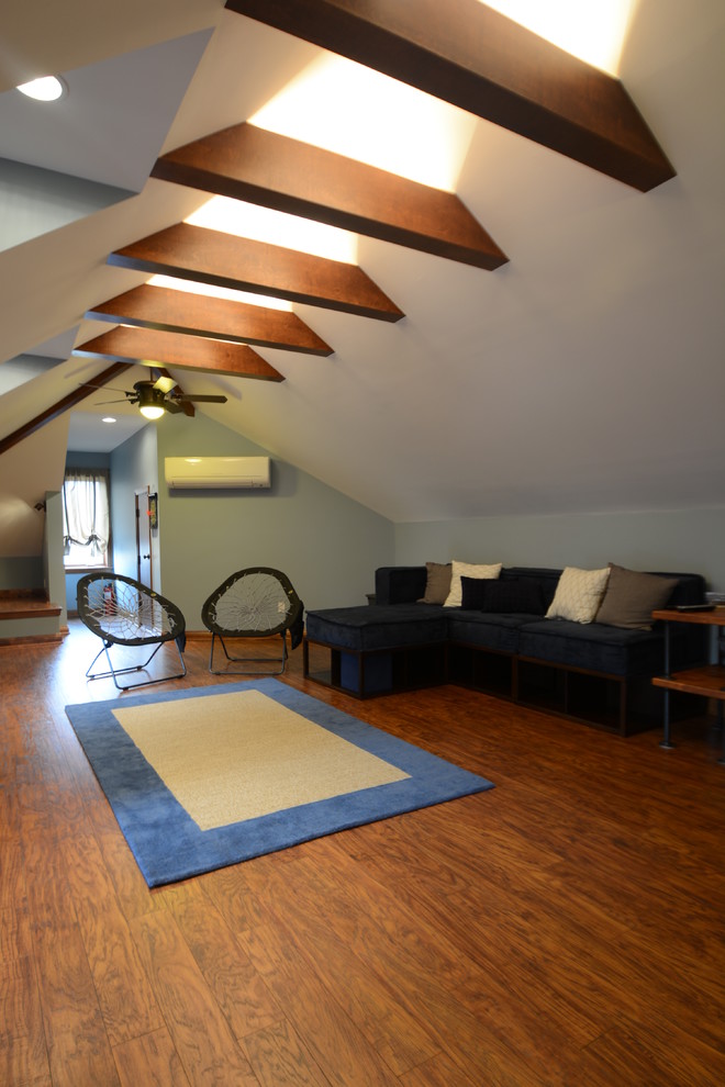 Idée de décoration pour un grand salon mansardé ou avec mezzanine chalet avec un mur bleu et un sol en bois brun.