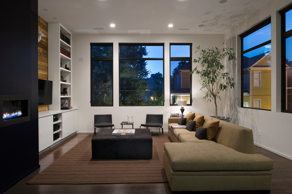 Foto di un soggiorno contemporaneo aperto con pareti bianche, pavimento in legno massello medio, camino classico, TV a parete e pavimento marrone