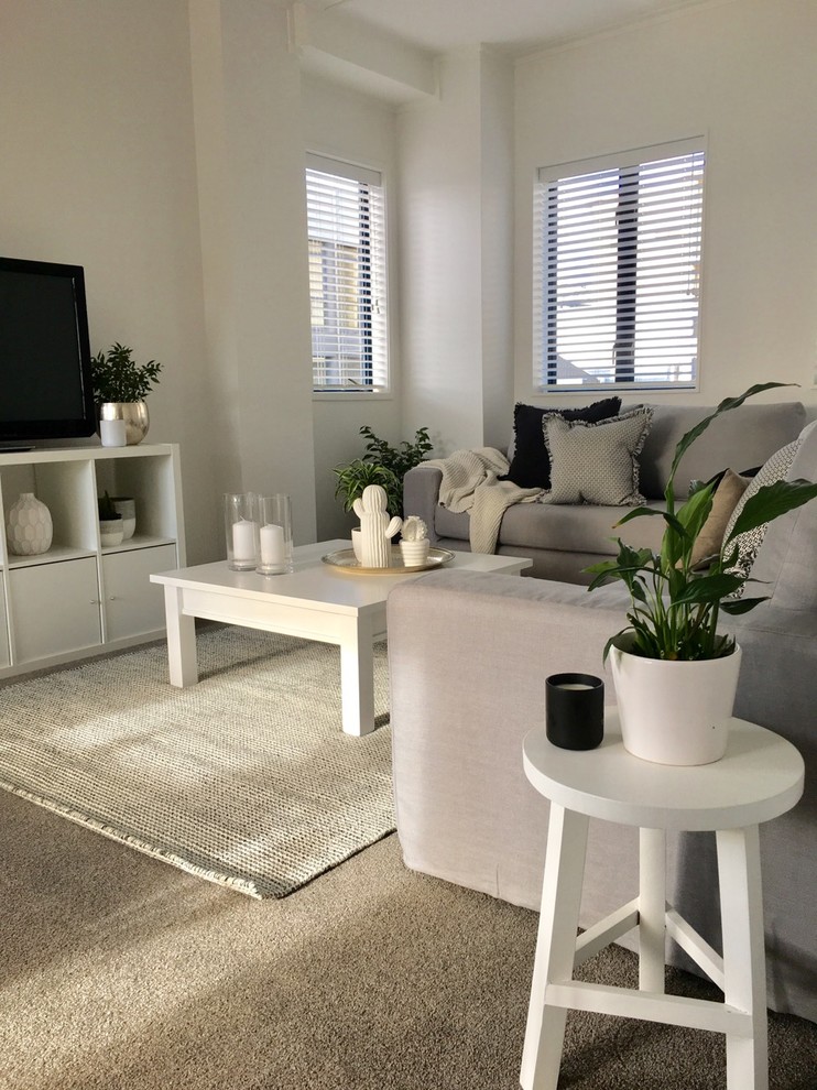 Exempel på ett litet modernt allrum med öppen planlösning, med vita väggar, heltäckningsmatta, en fristående TV och grått golv