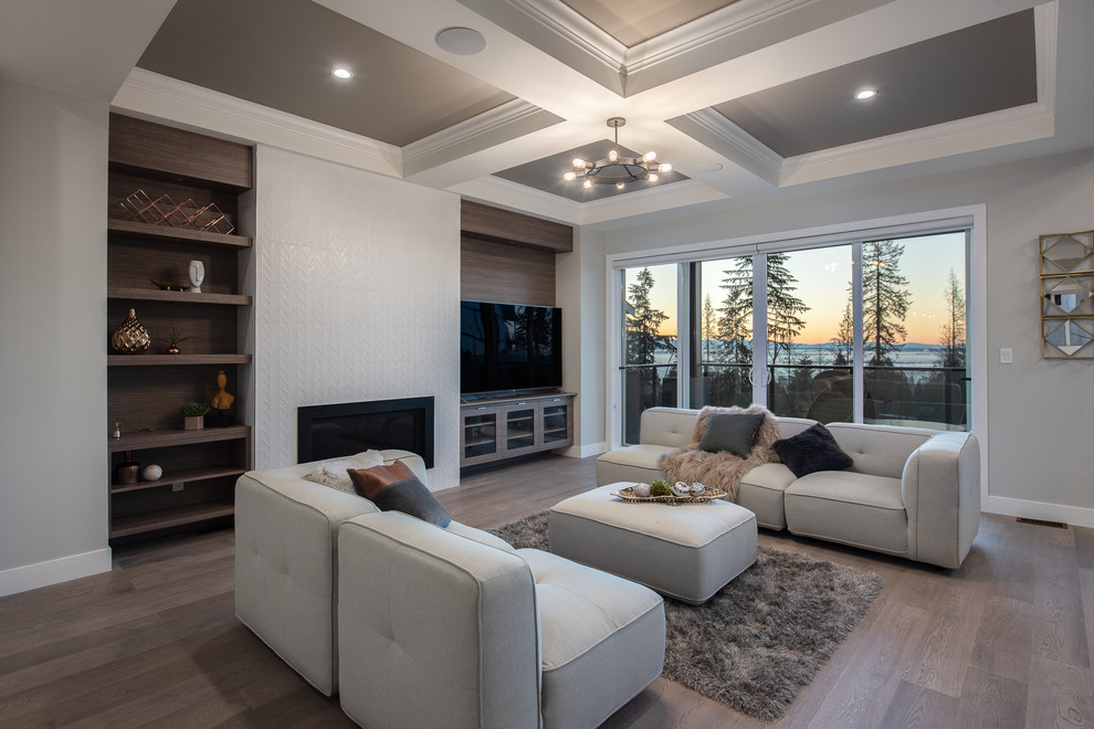 Inspiration for a modern open concept medium tone wood floor and brown floor living room remodel in Vancouver with gray walls, a standard fireplace, a tile fireplace and a media wall