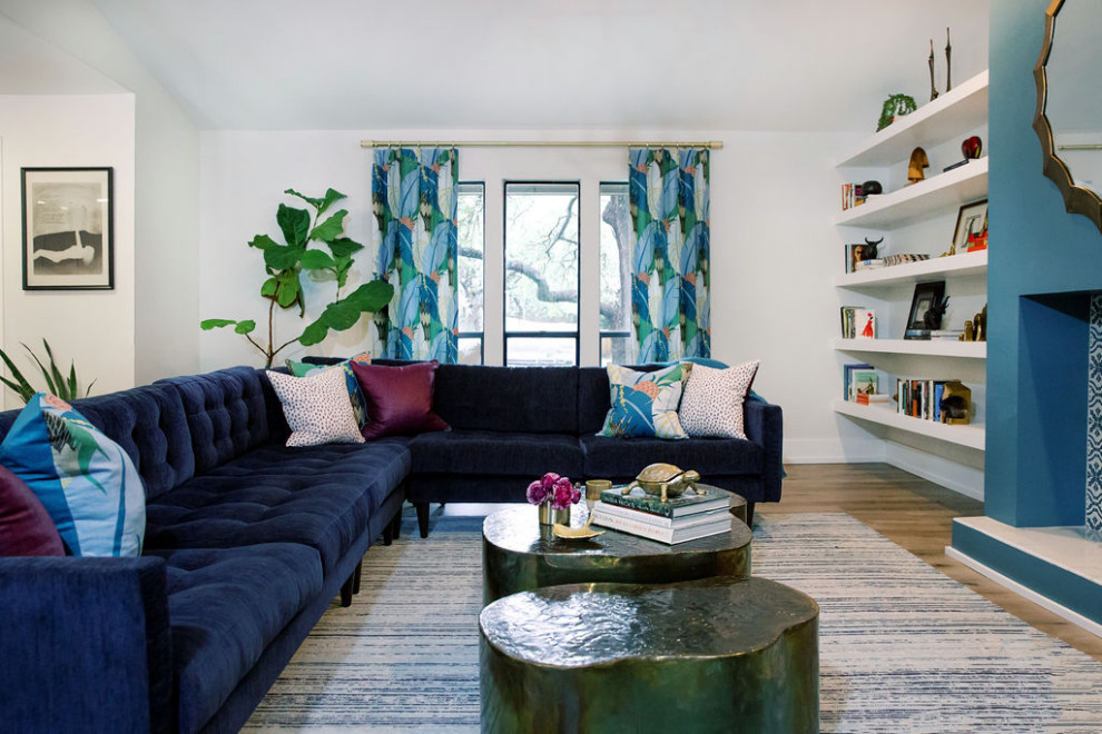 На фото: открытая гостиная комната среднего размера в стиле фьюжн с синими стенами, светлым паркетным полом, стандартным камином, фасадом камина из плитки, бежевым полом и балками на потолке с