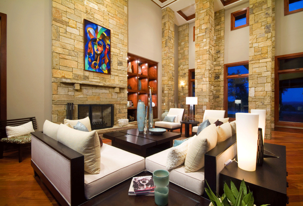 This is an example of a bohemian living room in Chicago with a stone fireplace surround and feature lighting.