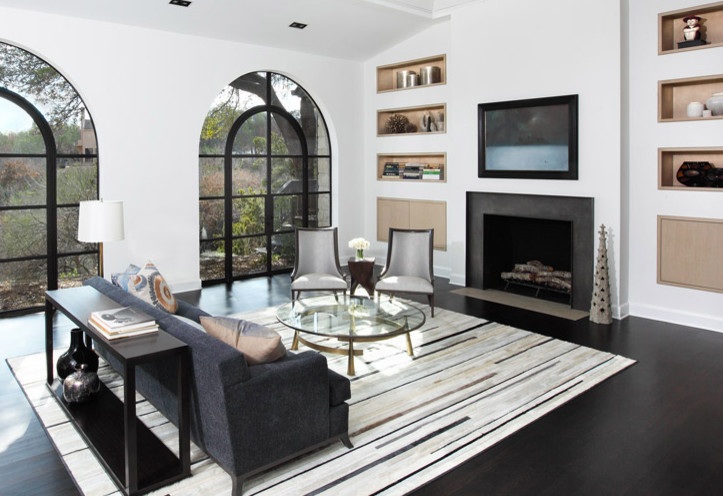 Cette image montre un grand salon design ouvert avec un mur blanc, parquet foncé, une cheminée standard, un manteau de cheminée en béton, un téléviseur encastré, une salle de réception et un sol noir.