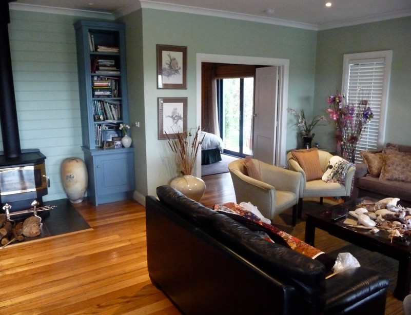 Idee per un soggiorno tradizionale di medie dimensioni e aperto con pareti nere, parquet chiaro e stufa a legna