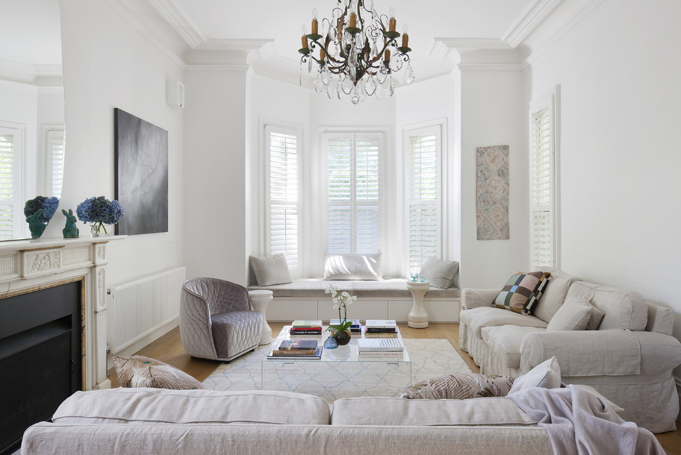 Esempio di un soggiorno tradizionale con sala formale, pareti bianche, parquet chiaro e camino classico