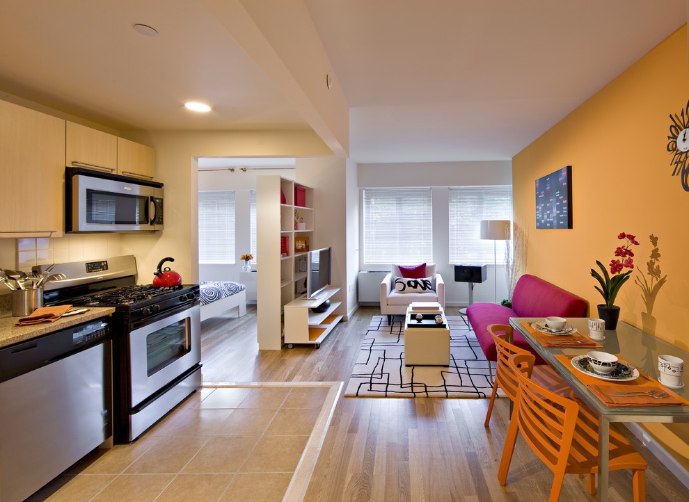 Esempio di un piccolo soggiorno minimal aperto con sala formale, pareti arancioni, parquet chiaro e TV autoportante