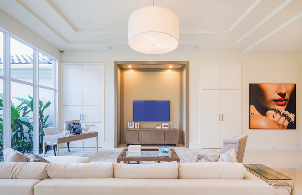 Modelo de salón abierto actual extra grande con paredes beige, suelo de baldosas de porcelana y televisor colgado en la pared