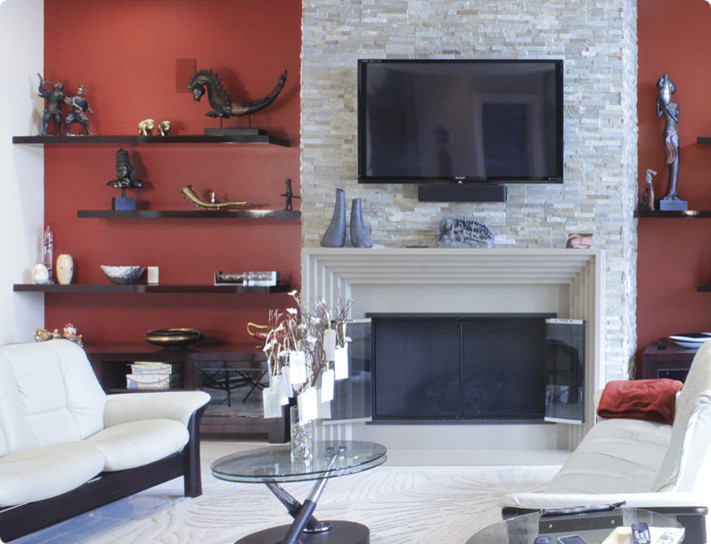 Diseño de salón abierto de tamaño medio con paredes rojas, todas las chimeneas, marco de chimenea de piedra y televisor colgado en la pared