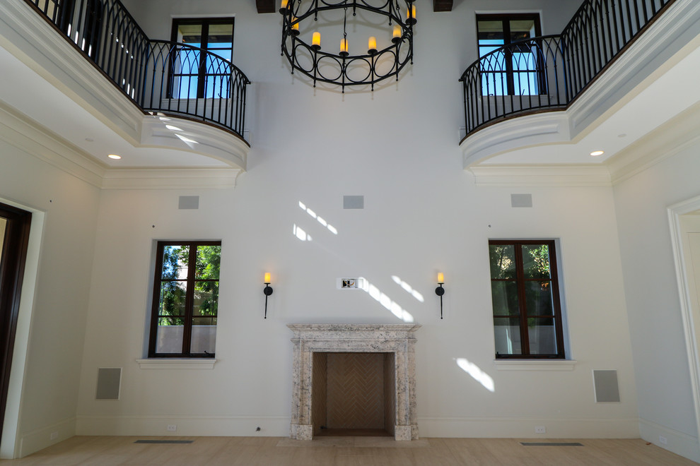 На фото: парадная, открытая гостиная комната среднего размера в средиземноморском стиле с белыми стенами, стандартным камином, фасадом камина из камня и полом из керамогранита без телевизора с