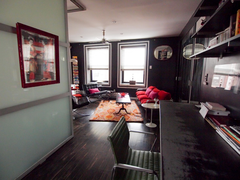 Modelo de salón tipo loft minimalista pequeño con paredes negras, suelo de madera oscura y televisor colgado en la pared
