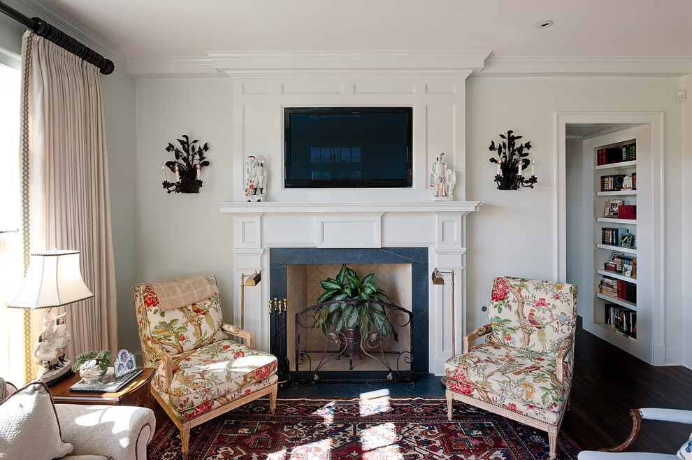 Exemple d'un grand salon chic fermé avec un mur beige, parquet foncé, une cheminée standard, un manteau de cheminée en bois, un téléviseur fixé au mur et une salle de réception.