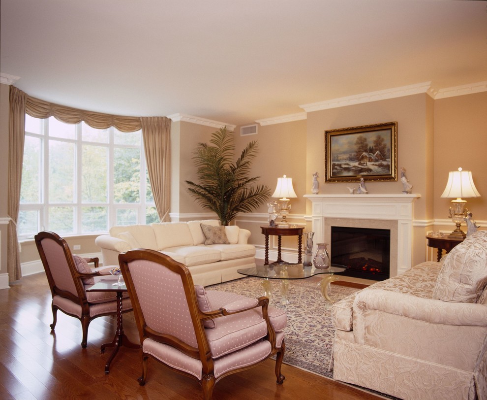 Example of a large classic formal and open concept medium tone wood floor living room design in Toronto with beige walls, a standard fireplace and a wood fireplace surround