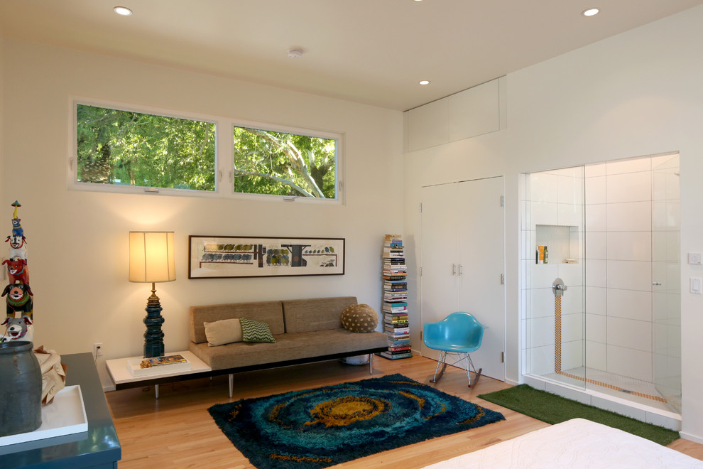Inspiration pour un salon minimaliste avec un mur blanc et un sol en bois brun.