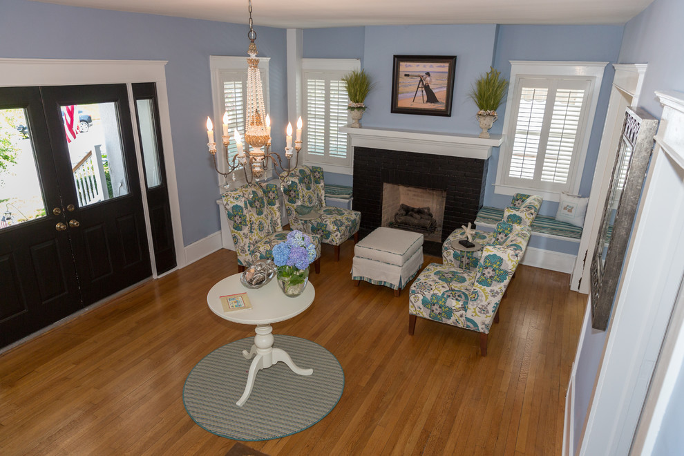 This is an example of a medium sized nautical enclosed living room in New York with blue walls, light hardwood flooring, no fireplace and no tv.