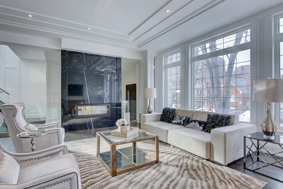 Inspiration for a large contemporary formal open plan living room in Toronto with white walls, medium hardwood flooring, a two-sided fireplace, a tiled fireplace surround, no tv and brown floors.