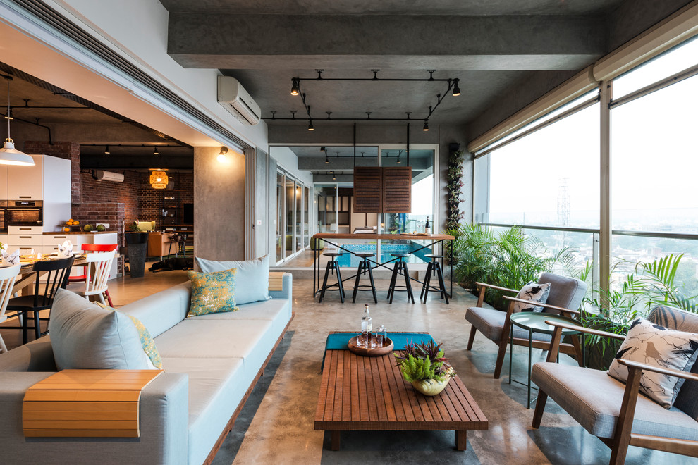 This is an example of an industrial conservatory in Ahmedabad with concrete flooring, no fireplace, a standard ceiling and grey floors.
