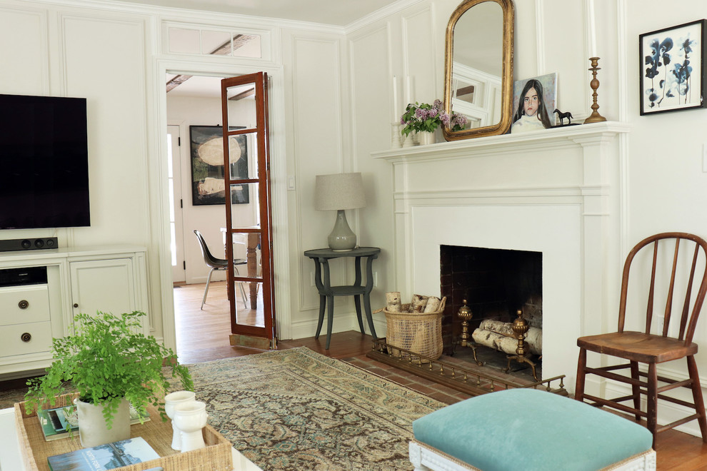 Kleines, Repräsentatives, Abgetrenntes Klassisches Wohnzimmer mit weißer Wandfarbe, braunem Holzboden, Kamin, verputzter Kaminumrandung, TV-Wand und braunem Boden in New York