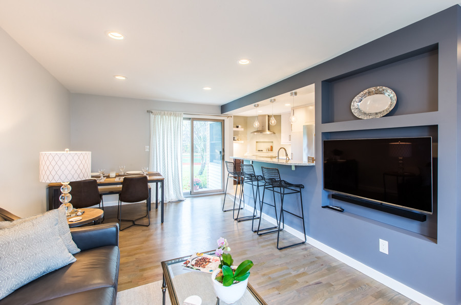 Mittelgroßes, Offenes Modernes Wohnzimmer ohne Kamin mit grauer Wandfarbe, hellem Holzboden und TV-Wand in Boston