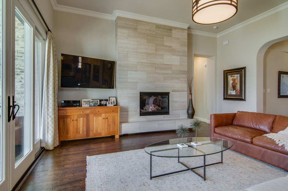Großes, Offenes Klassisches Wohnzimmer mit beiger Wandfarbe, braunem Holzboden, Kamin, gefliester Kaminumrandung, TV-Wand und braunem Boden in Dallas