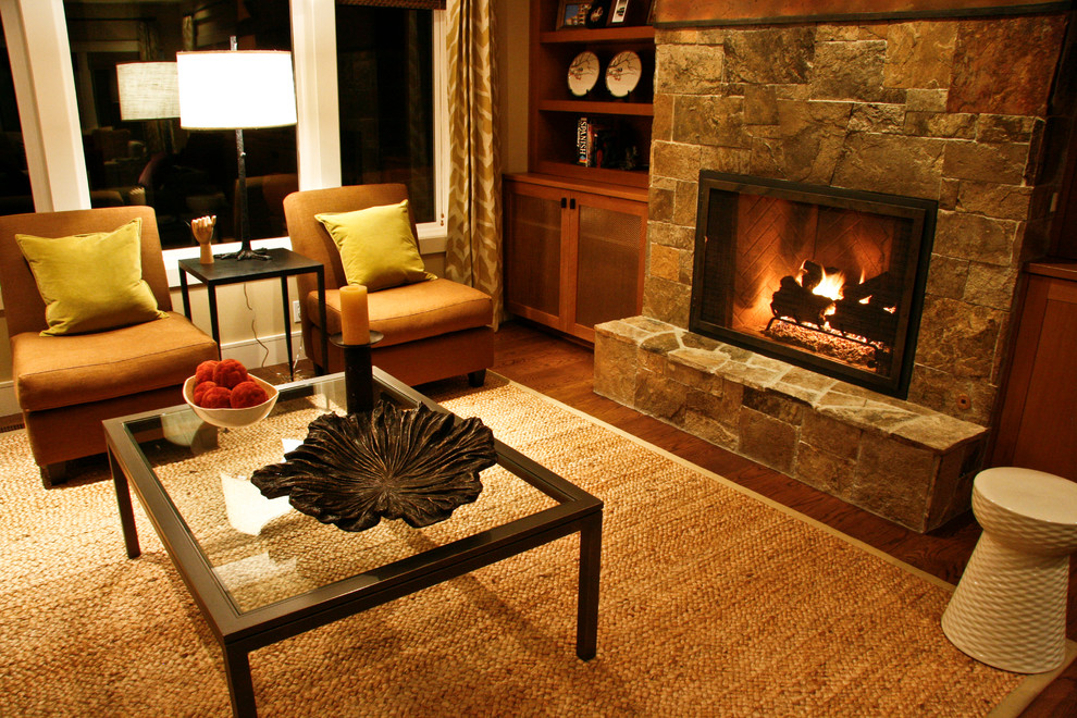 Foto di un soggiorno minimalista di medie dimensioni con pareti beige, pavimento in legno massello medio, camino classico e cornice del camino in pietra