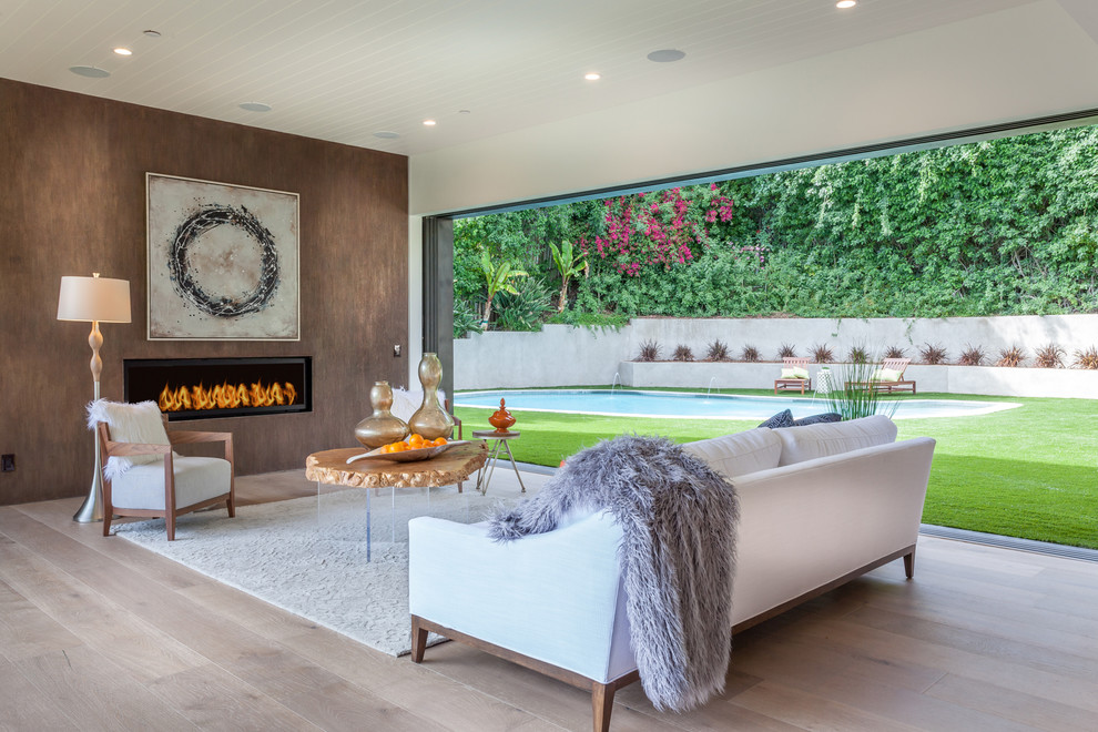 Diseño de salón abierto actual de tamaño medio sin televisor con paredes marrones, suelo de madera clara, chimenea lineal y suelo beige