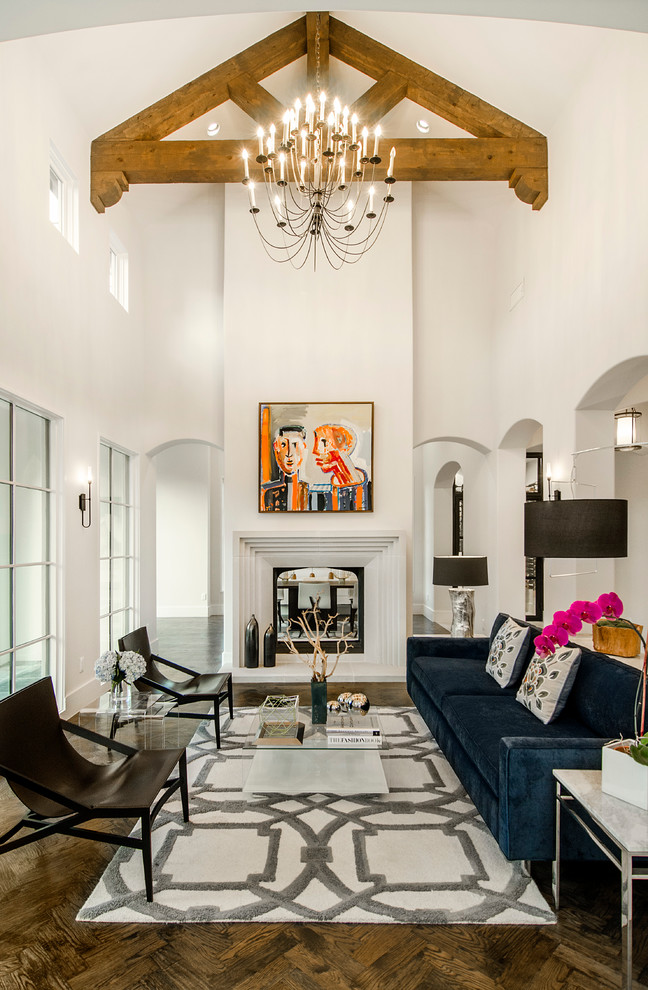 Стильный дизайн: гостиная комната в средиземноморском стиле с белыми стенами, темным паркетным полом, стандартным камином и синим диваном без телевизора - последний тренд