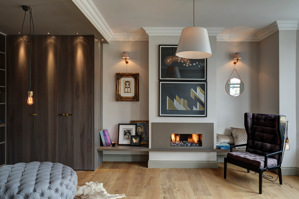 Modernes Wohnzimmer mit beiger Wandfarbe, hellem Holzboden und Gaskamin in London
