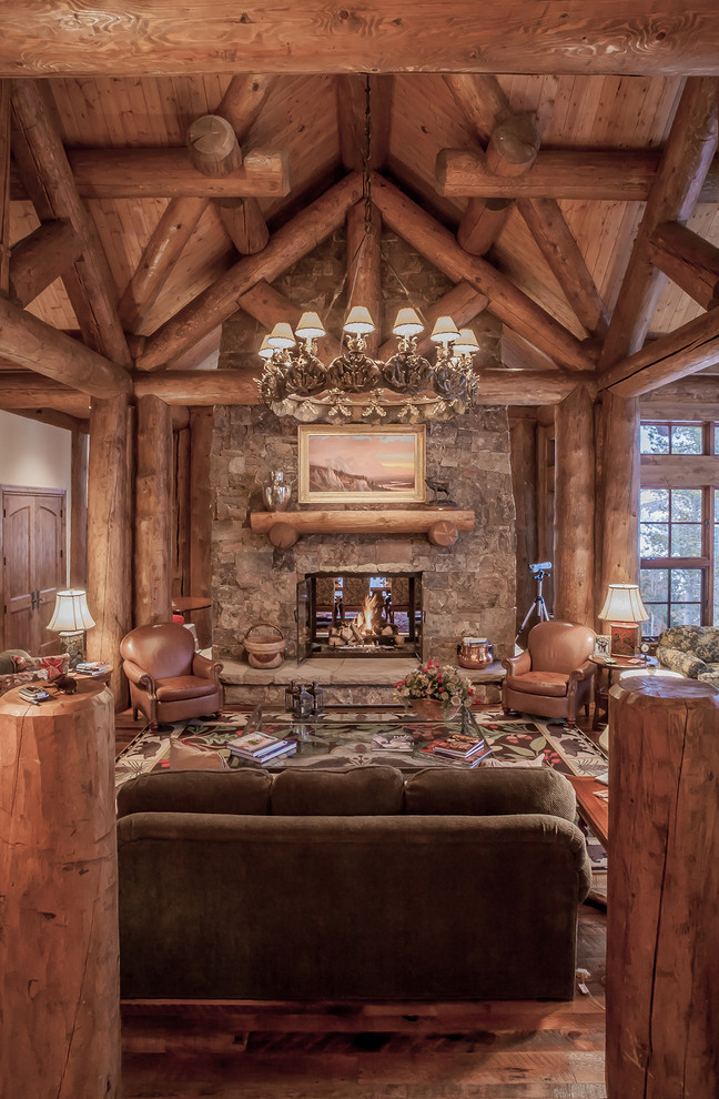 Photo of a rustic living room in Denver with a stone fireplace surround.