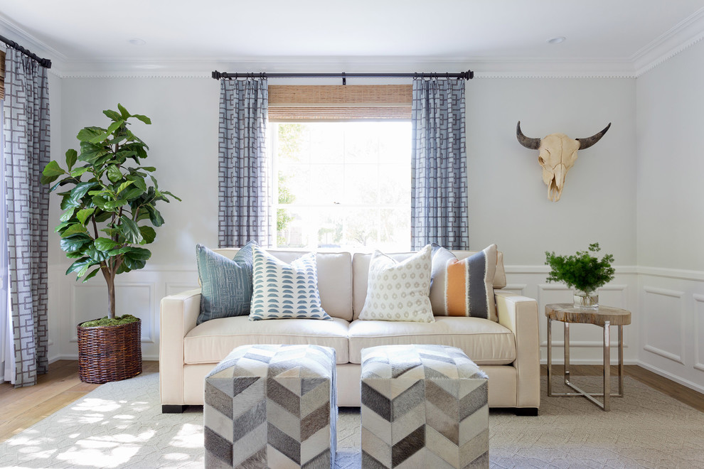 This is an example of a coastal living room curtain in Orange County with grey walls and light hardwood flooring.