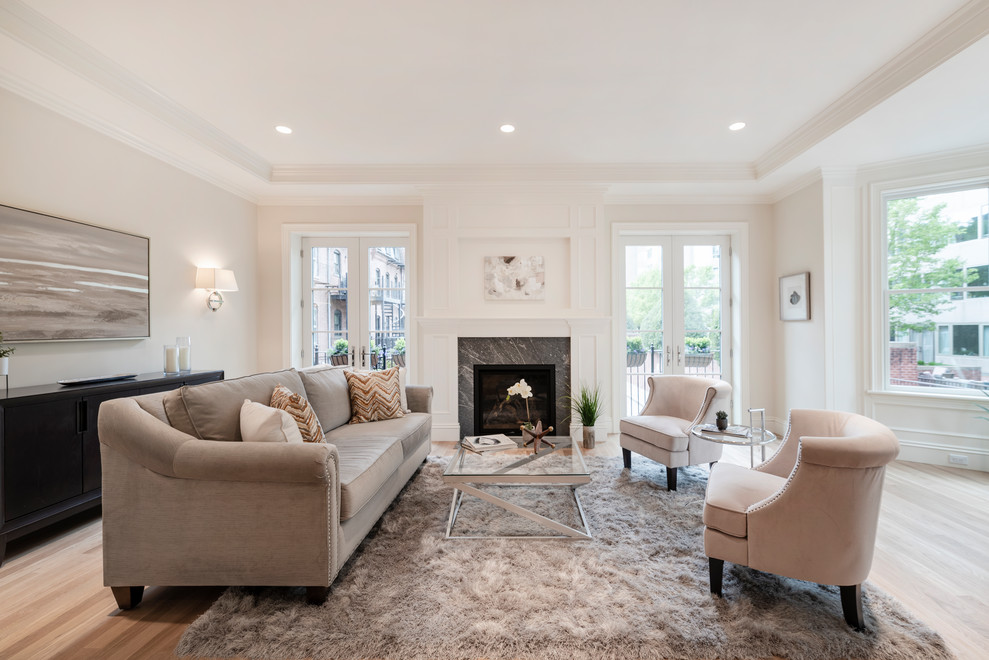 Offenes Klassisches Wohnzimmer mit weißer Wandfarbe, hellem Holzboden, Kamin und Kaminumrandung aus Stein in Boston