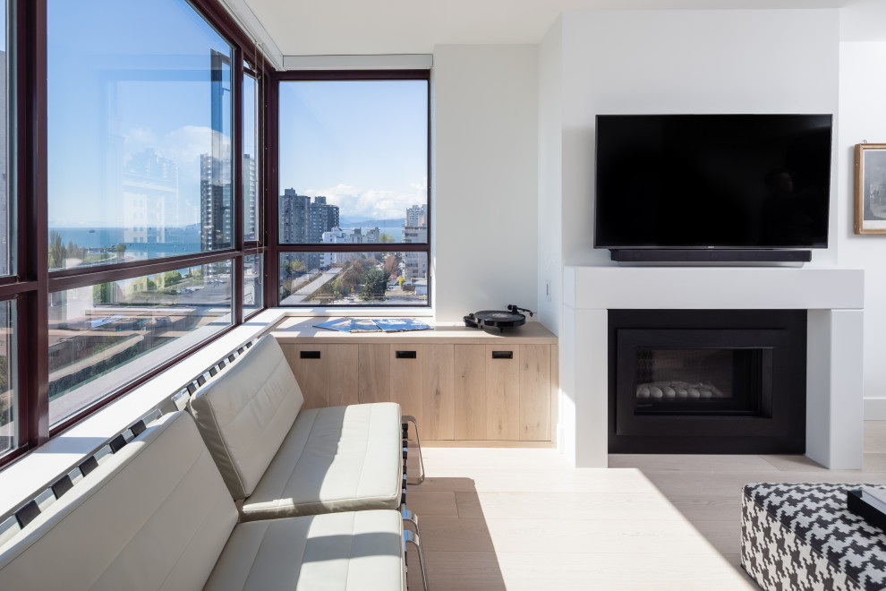 Kleines, Offenes Modernes Wohnzimmer mit weißer Wandfarbe, hellem Holzboden, Kamin, Kaminumrandung aus Beton, TV-Wand und beigem Boden in Vancouver
