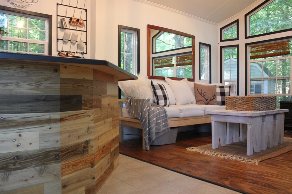 Immagine di un piccolo soggiorno minimal aperto con pareti bianche, pavimento in legno massello medio e pavimento marrone