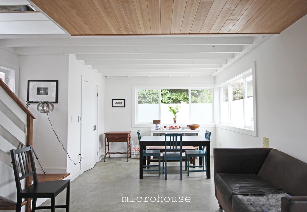 На фото: маленькая открытая гостиная комната в современном стиле с белыми стенами и бетонным полом для на участке и в саду с
