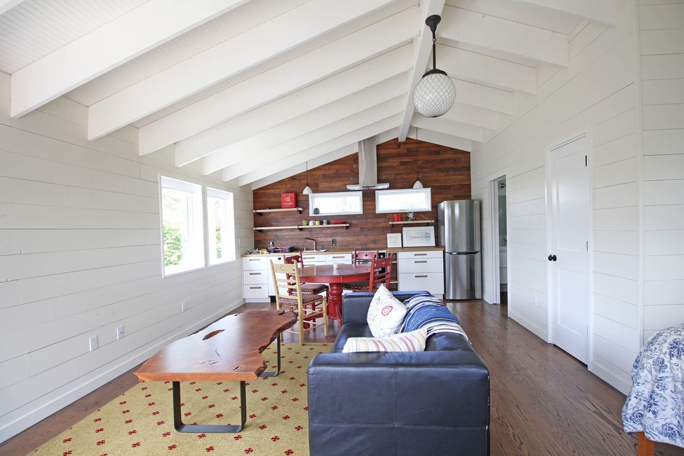 Immagine di un piccolo soggiorno classico aperto con pareti bianche, pavimento in legno massello medio e pavimento marrone