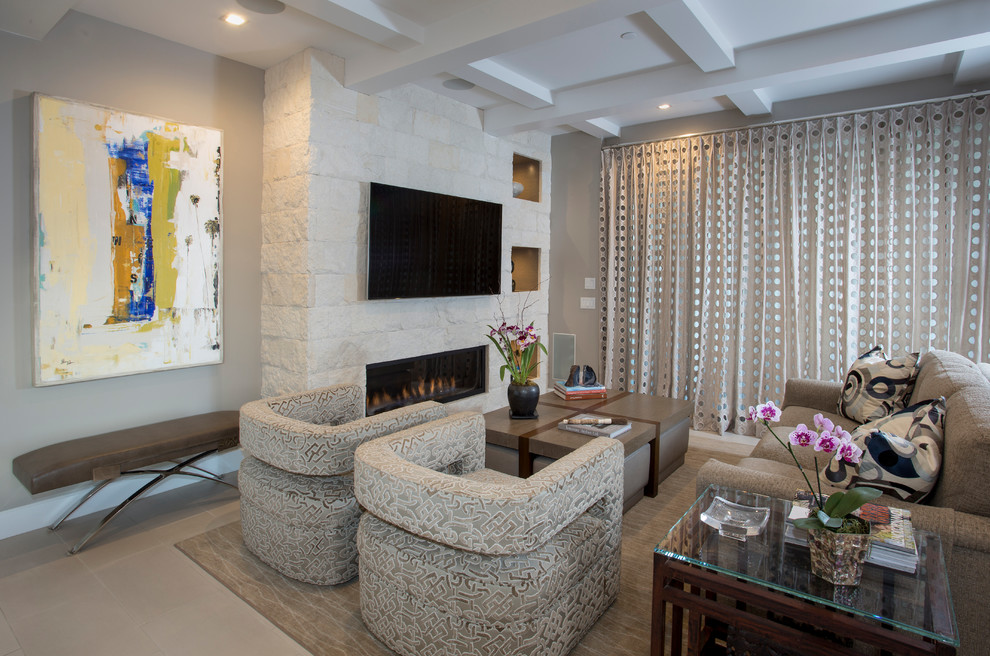 Ejemplo de salón abierto costero con paredes beige, chimenea lineal, marco de chimenea de piedra y televisor colgado en la pared