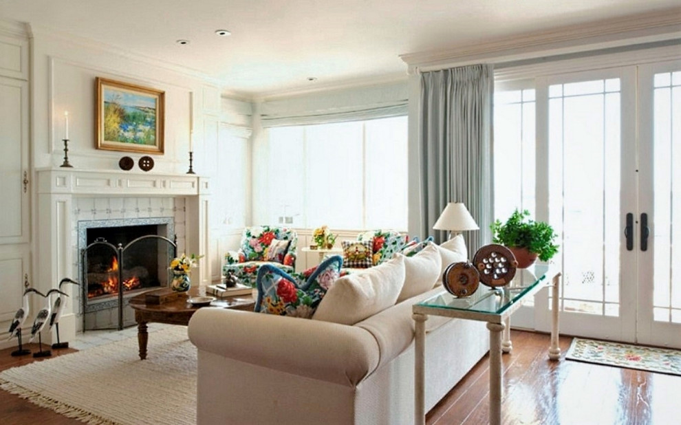 На фото: открытая гостиная комната среднего размера в морском стиле с синими стенами, паркетным полом среднего тона, стандартным камином, фасадом камина из плитки и скрытым телевизором с