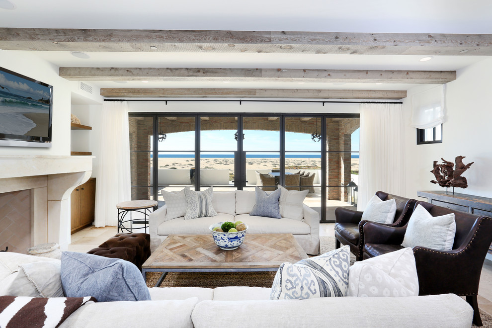Esempio di un soggiorno costiero di medie dimensioni e aperto con pareti bianche, camino classico, TV a parete, sala formale e parquet chiaro